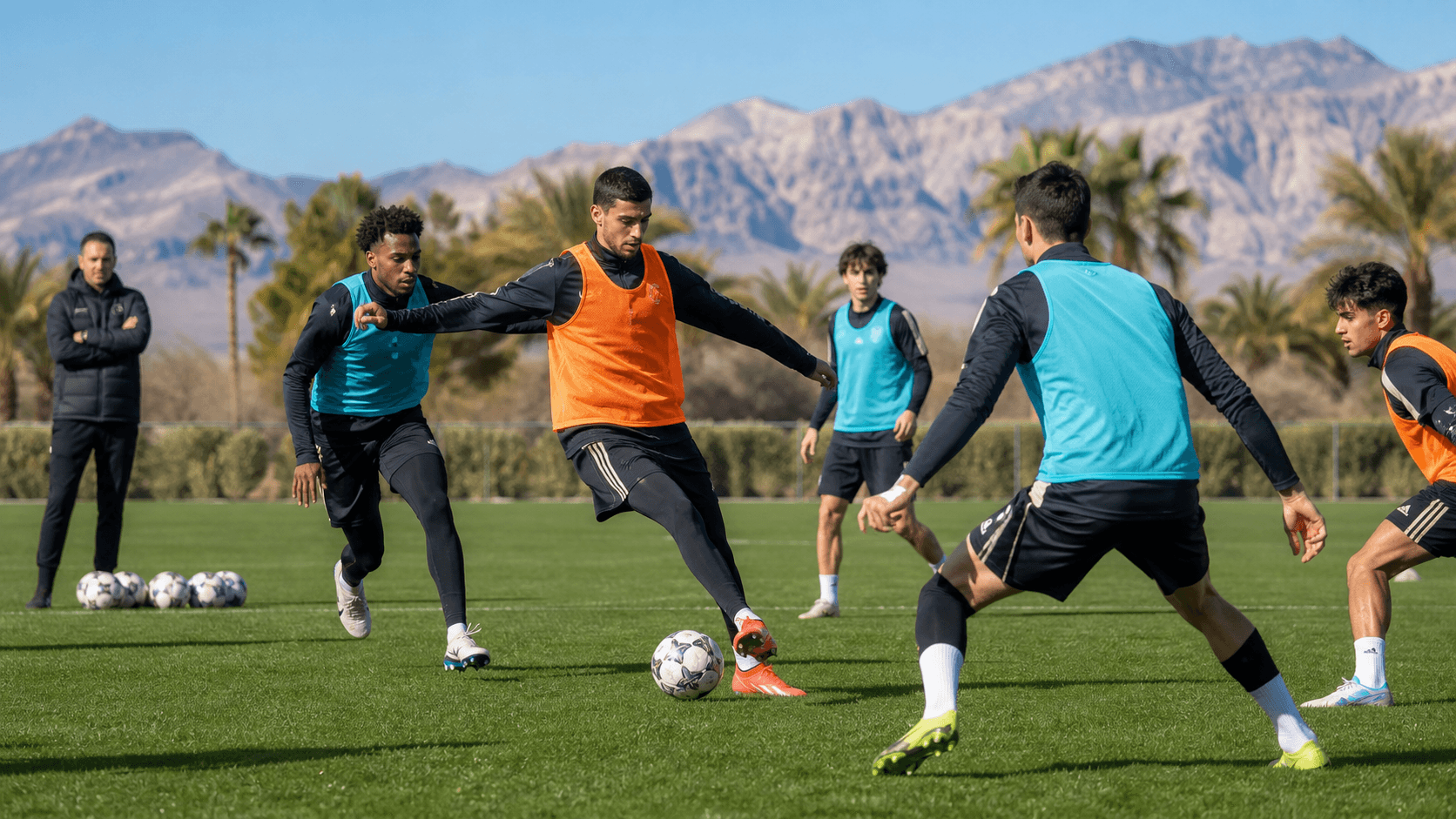 Youth soccer players practice on a sunlit Las Vegas field with palm trees and desert mountains behind them.